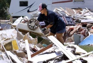 Liz Cruz dumps debris from her brother-in-law's house Aug. 23 following flooding in Denham Springs, La. In a Sept. 19 interview, Robert Gorman, executive director of Catholic Charities of the Diocese of Houma-Thibodaux, called upon the presidential candidates and elected officials to take seriously the threat of flooding and disappearing land not just in Louisiana, but also in other coastal communities. CNS photo/Jonathan Bachman, Reuters 