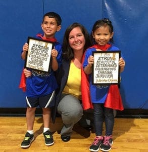 Immaculate Heart of Mary School principal Kellie DesOrmeaux poses with “superhero” students at the school’s Childhood Cancer Awareness Month event. The students received their capes and a plaque for their “courage and unending strength” in their fights against cancer.