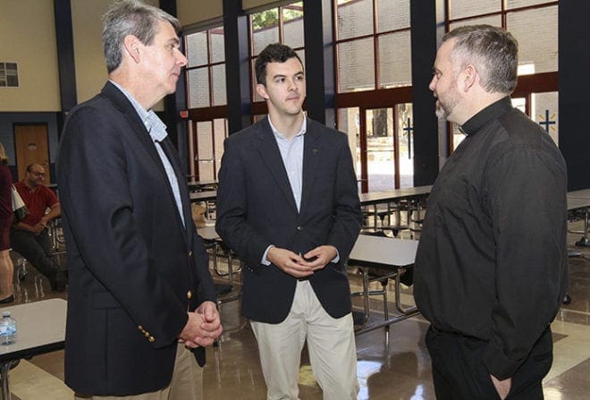 (R-l) Jesuit Father Thomas Kenny, vice president for Mission and Ministry, Religious Studies, at Cristo Rey Atlanta Jesuit High School, chats with Caleb Weaver and his dad Robert during a reception for Jesuit Friends and Alumni Sunday at St. Thomas More Church’s Mulhern Hall. Caleb is a 2016 graduate of Georgetown University, Washington, D.C. Father Kenny, a graduate of Boston College and Loyola University in Chicago, resides at the Decatur parish. Photo By Michael Alexander