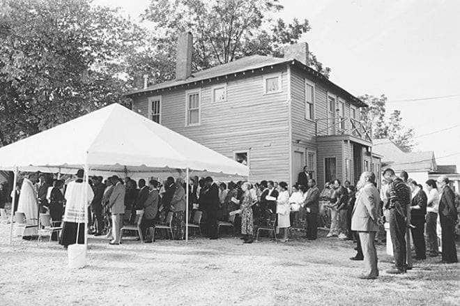 The former Atlanta University Catholic Center, the house in the background, was blessed Oct. 20, 1991 during a ceremony officiated by the late Archbishop James P. Lyke, OFM, far left under the tent. Photo By Michael Alexander