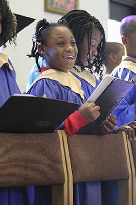 Eight-year-old Alexia Whitehead joins fellow members of the children’s choir as they participate in the parish Mass of Rededication. The Burmese, Filipino, gospel, Spanish and traditional choirs also came together to form one choir during the liturgy. Diane Ross directed the children’s choir. Photo By Michael Alexander