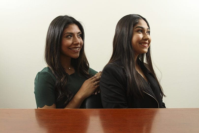 Karla Sandoval, left, and her cousin, Frida, pose for a photograph at Divino Niño Jesús Mission, Duluth. They were photographed with Archbishop Wilton D. Gregory 14 years ago during his canonical installation as Atlanta's new archbishop.