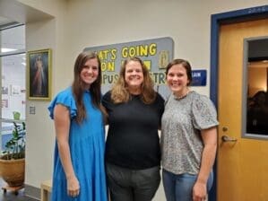 three women pose for picture outside of St. Pius X offices as campus ministry