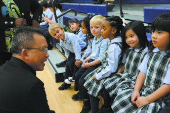 Bishop John N. Tran talks to St. John the Evangelist School students before the Jan. 19 MLK Youth Celebration program, asking them about their planned performance.